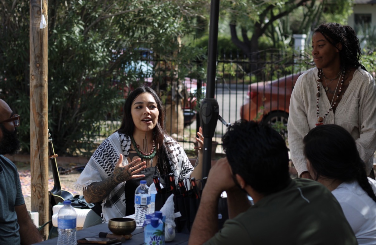Ryanne smiling mid-conversation around the table, gesturing as she speaks during a gathering