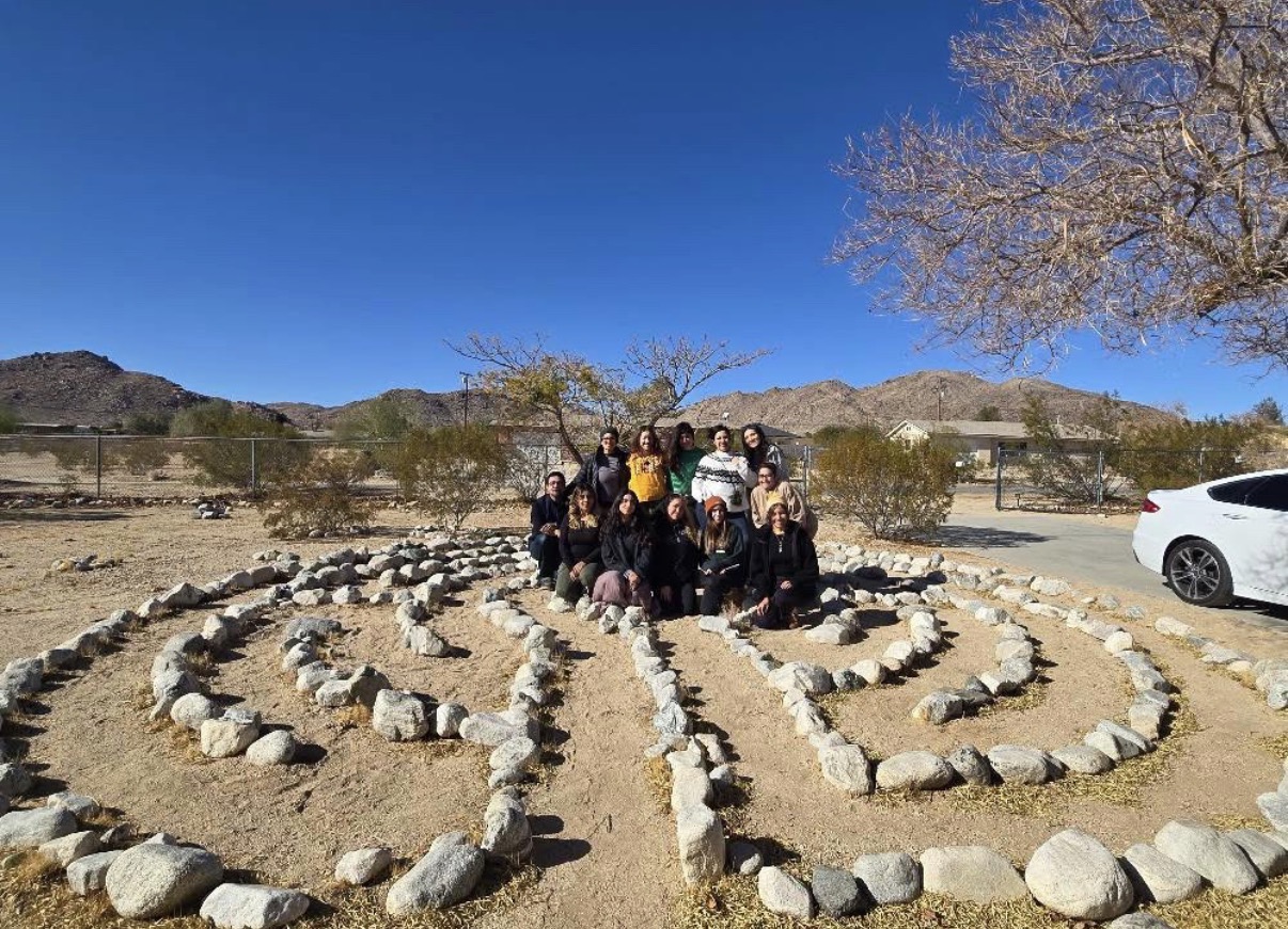 Group gathered within a rock labyrinth under a desert sky