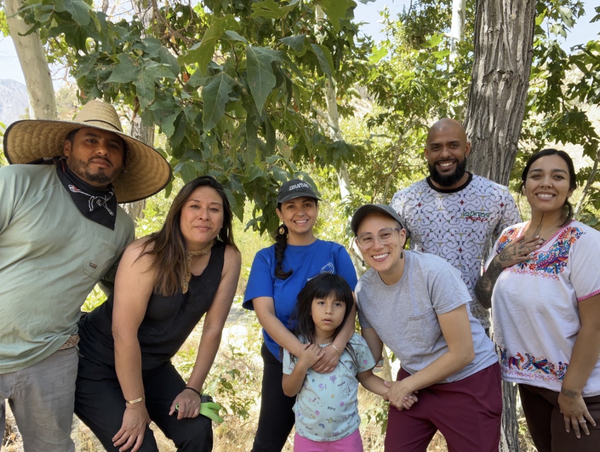 Community volunteers gathered together under the trees on a river cleanup day