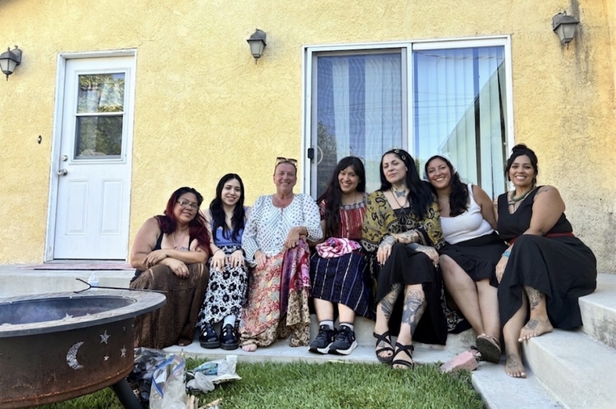 Group of women seated together on the steps beside the fire pit